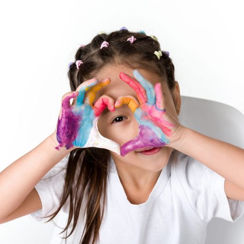 little child girl with hands painted in colorful paint