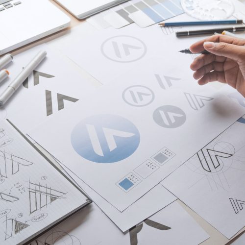 Graphic designer drawing sketch design creative Ideas draft Logo product trademark label brand artwork. Graphic designer studio Concept.